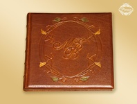 Oryginalny ręcznie robiony album do zdjęć, w skórzanej oprawie ozdobnej, z inicjałami reliefowymi i intarsjami. Brązowa skóra naturalna i brązowe karty w środku.